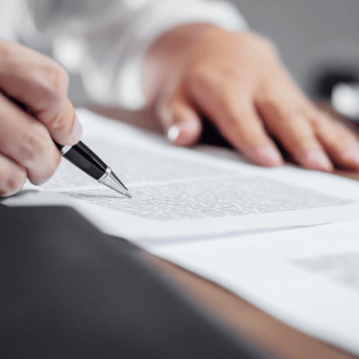 Hand holding pen on paper document