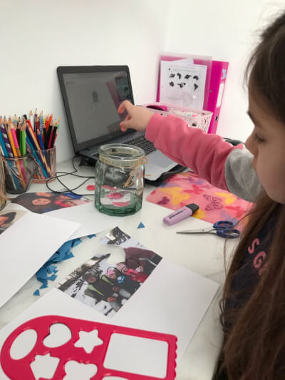 Photograph of child putting her heart-shaped cards into a jar.