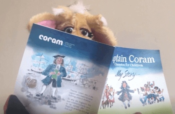 Harold the giraffe reading Captain Coram - the man who saved children book.